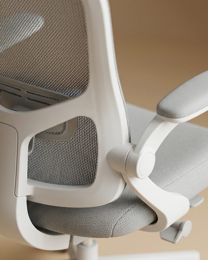 Gros plan sur le dossier mesh, l'accoudoir relevable et l'assise de la chaise gris clair