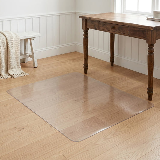 Tapis protège-sol transparent posé sur un parquet en chêne clair, sous un bureau